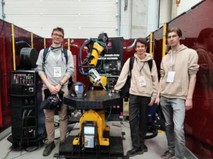 żółty robot - ramie robota-trzech studentów